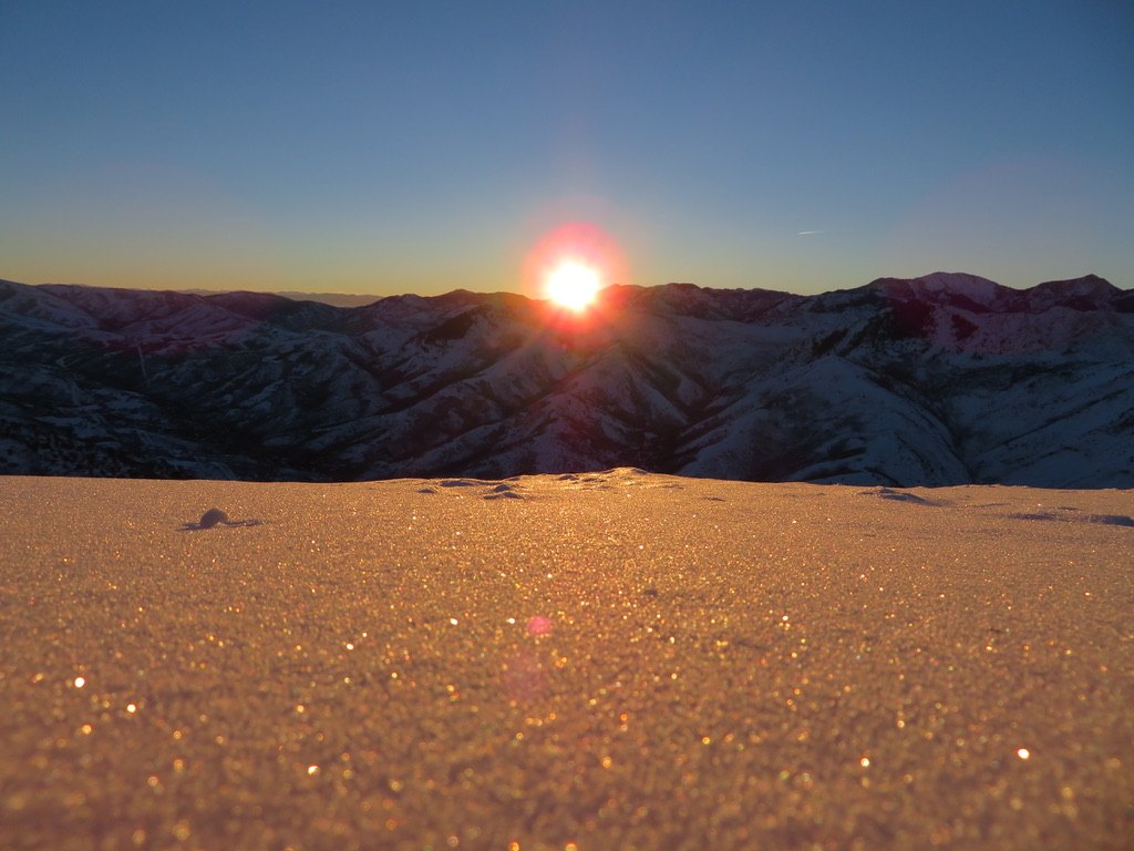 Sunset over glittering snow and winter ridges
